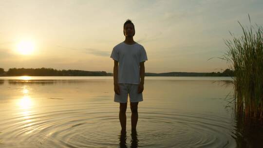一个年轻人站在湖水中