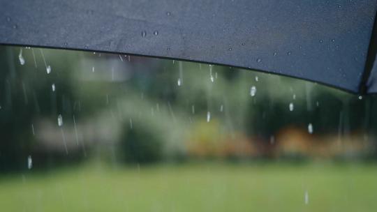 下雨时水滴从灰色伞的表面流下来1