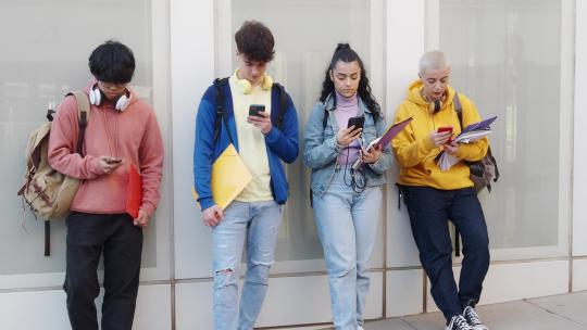 一群年轻学生玩手机