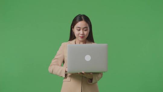 女商人在绿幕上使用笔记本电脑