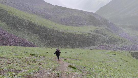 攀登甘孜那玛峰的登山者在冰雹中徒步行进