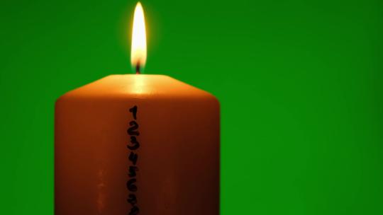 绿色色度关键背景上带有降临日历的蜡烛传统燃烧圣诞蜡蜡烛