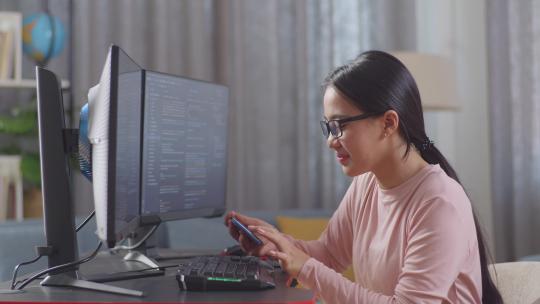 亚洲少女程序员在创建软件工程师开发应用程序时使用智能手机视频素材模板下载