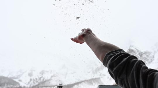 在瑞士阿尔卑斯山采尔马特的阳台上，一个人向空中扔了一把雪