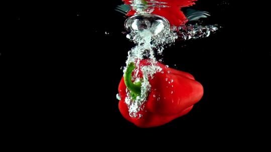 红色彩椒掉入水中的慢动作