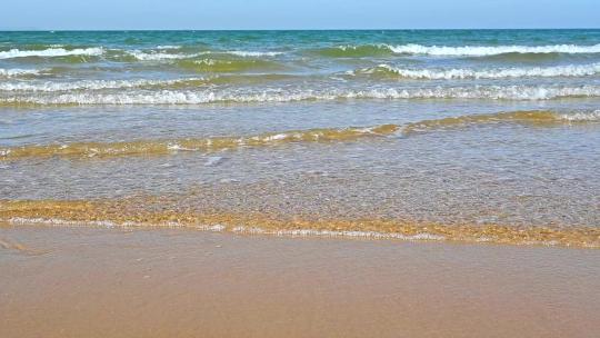 夏天的海边海滩上波浪泛起朵朵浪花慢镜