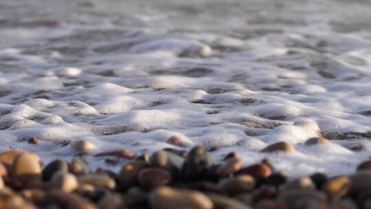 海浪涌向堆积在海边的鹅卵石