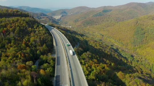 航拍车辆行驶在山间的高速公路上