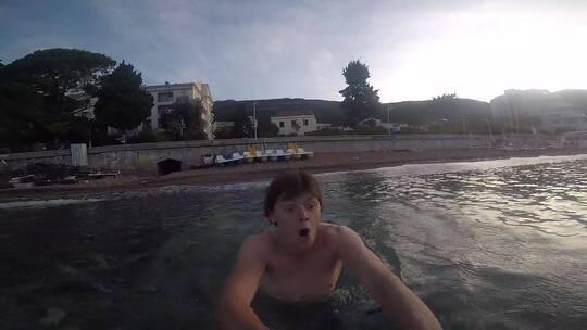 一名男子在游泳时拿着水下摄像机拍摄