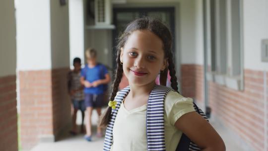 快乐的高加索女孩站在学校走廊的视频