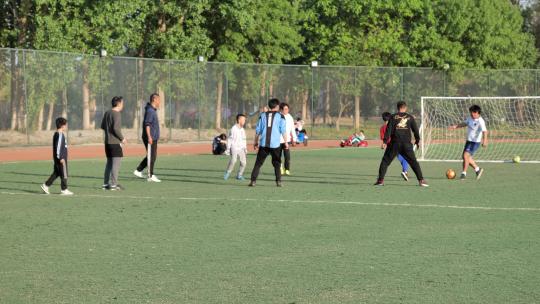 公园足球场踢足球的年轻人 慢动作