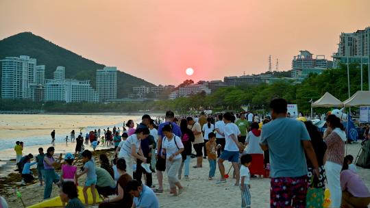 三亚大东海景区沐浴在夕阳余晖下的游客市民