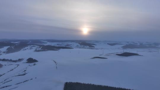 航拍冷空气笼罩的苍茫雪原夕照