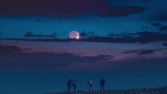 夜晚团队4人在月光下山顶徒步旅行