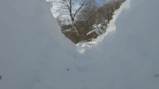 徒步旅行者拿着杆子在雪地里行走的低角度拍摄