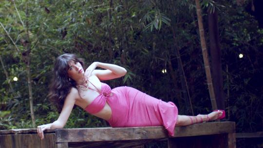 模特穿着美人鱼姿势的粉色连衣裙。-慢动作
