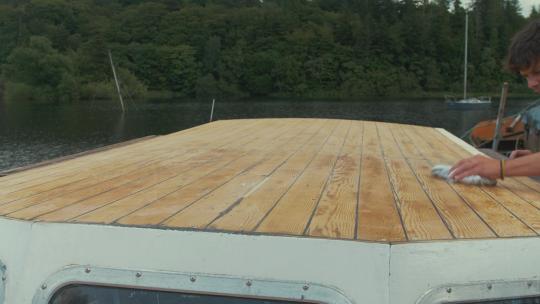 用布和油漆稀释剂擦拭木船屋顶