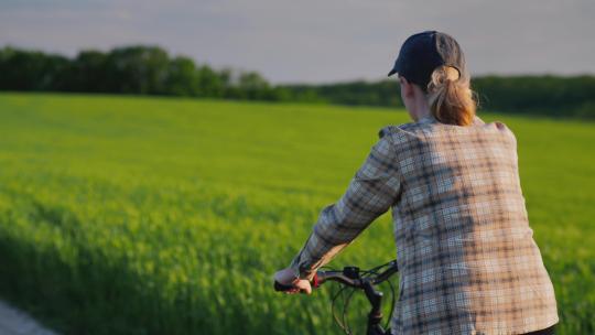 女人在农田路上骑自行车
