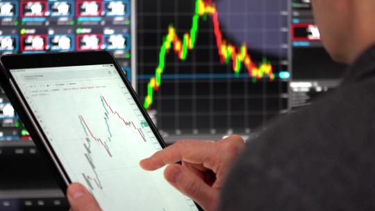 商人在平板上分析股票图表视频素材模板下载