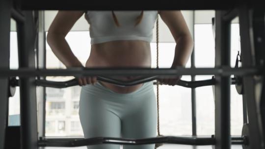 怀孕的现代女性在健身房锻炼身体撸铁