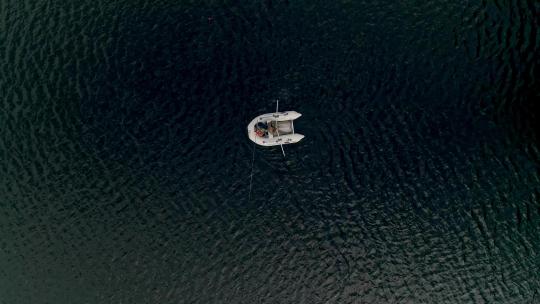 两个渔民在橡胶充气船上钓鱼08的自上而下的湖泊鸟瞰图