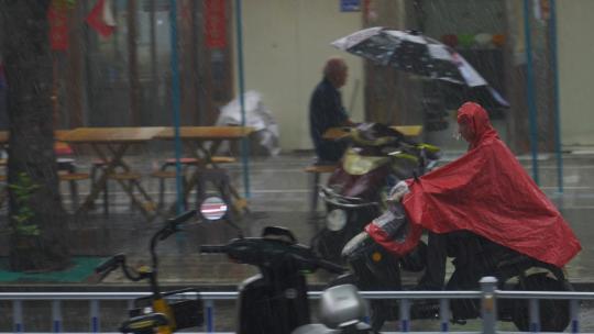 暴雨下雨打伞淋雨雨中冒雨骑电动车辛苦打拼