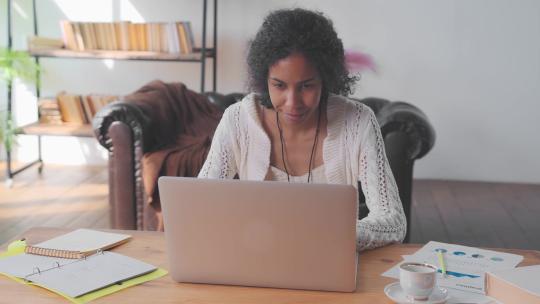 年轻的非裔美国女会计师在办公室桌子上使用笔记本电脑