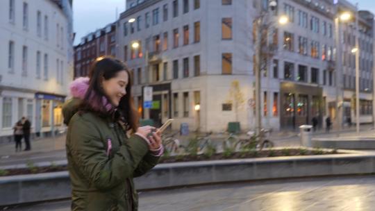 年轻女子在伦敦街头使用手机