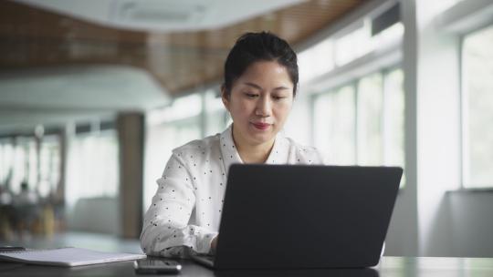 职业女性在办公室用笔记本电脑工作视频素材模板下载