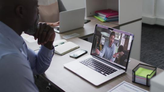 非裔商人使用笔记本电脑与同事进行视频通话