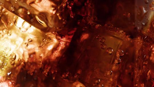 可乐和冰块透过灯光金盈剔透的画面特写