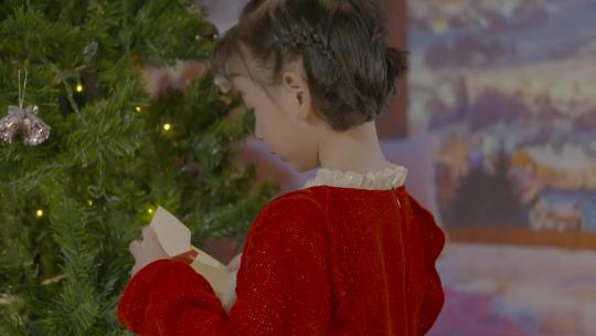 唯美欧美圣诞节氛围小孩打开圣诞树上的贺卡