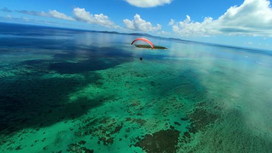 FPV无人机航拍滑翔伞飞行在海滩上空