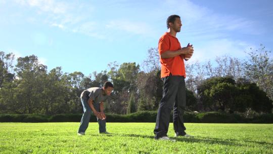 一位父亲教他的儿子如何踢美式足球。