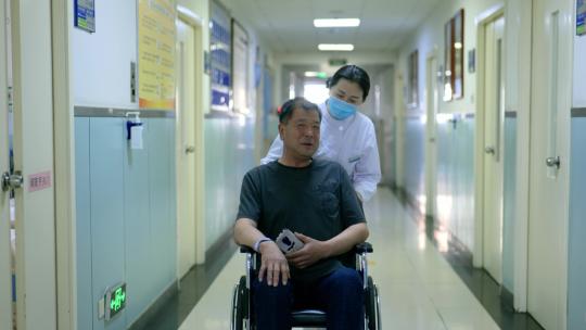 护士推着轮椅上的病人走在走廊里