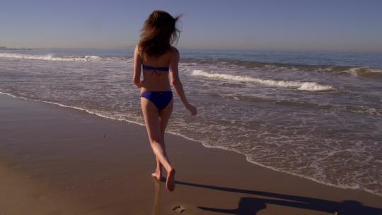 穿比基尼奔跑在沙滩上的女人视频素材模板下载