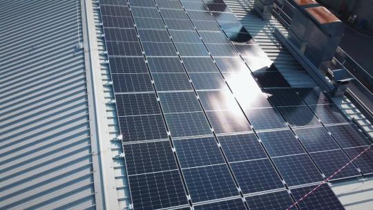 太阳能板在工业建筑顶部的太阳反射，可再生能源系统视频素材模板下载
