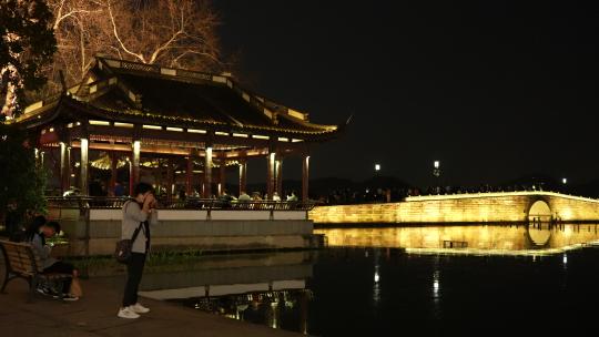夜晚杭州西湖上的断桥和行人