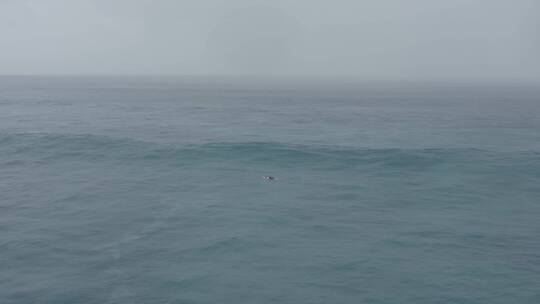 一个人骑冲浪板在海上冲浪