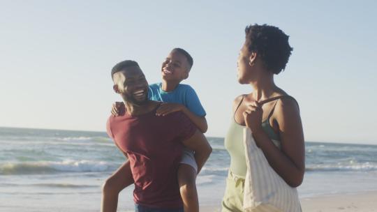 快乐的黑人家庭在海滩上玩得开心的视频