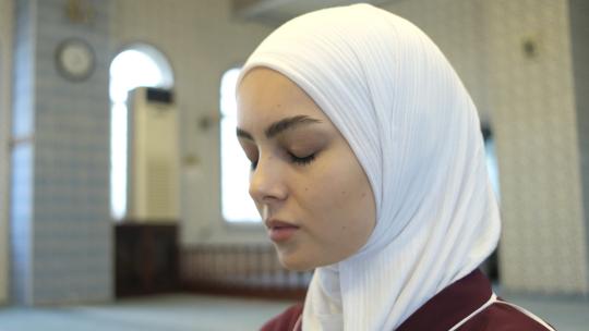 穆斯林高加索女孩，向天空举起双手请求原谅，清真寺里戴着头巾的崇拜女孩的形象，伊斯兰行为