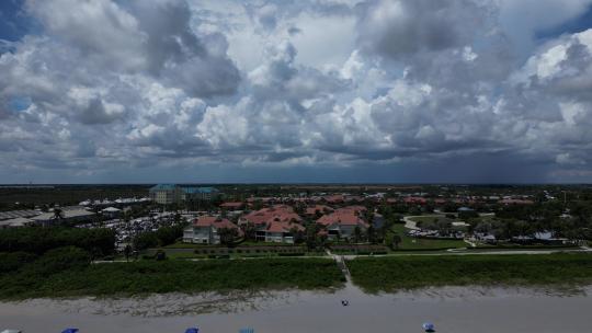 佛罗里达州沿海海滩的无人机镜头，有粉红色屋顶的豪华别墅。