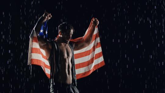 披着国旗雨中欢呼的男人