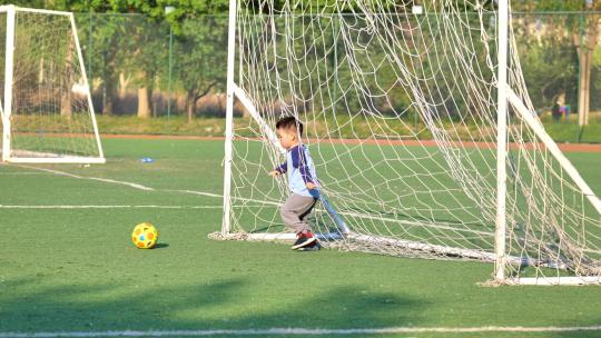 开心的小朋友踢足球守球门慢动作