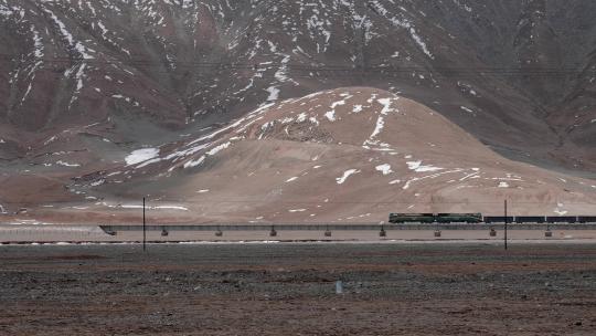 玉珠峰下行驶在青藏铁路上的火车