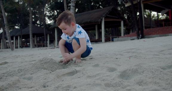 男孩用沙子建造房子