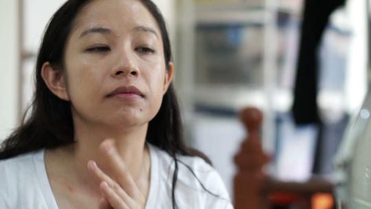 亚洲女人在慢动作化妆前在脸上涂粉底