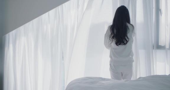 纯白家居女生起床看向窗外