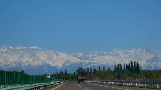 驾驶员视角北疆雪山下的高速公路
