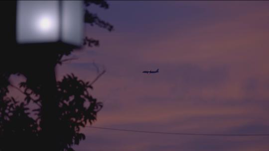 飞机飞过傍晚的彩霞里